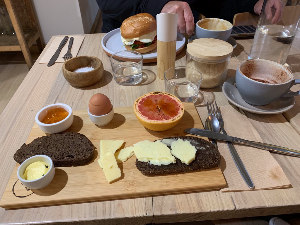 Die Frühstückslokale haben tolle Dinge zum Frühstück. Das getoastete dunkle Brot mit Hartkäse, Orangenmarmelade, Ei und mit einer dünnen flambierten Karamellschicht überzogenen halben Grapefruit war köstlich! Leigh hatte einen Frühstücksburger mit Spiegelei, im Hintergrund zu sehen