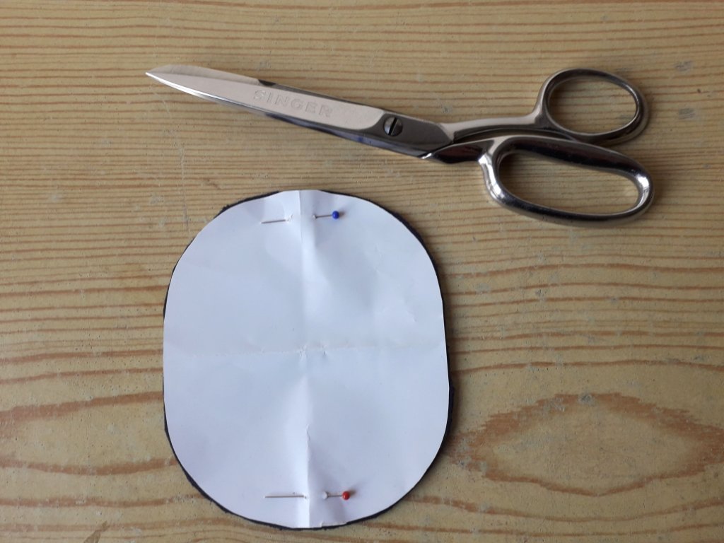 1) Schablone aus Papier anfertigen und auf den farblich passenden Stoffrest gesteckt und ausgeschnitten